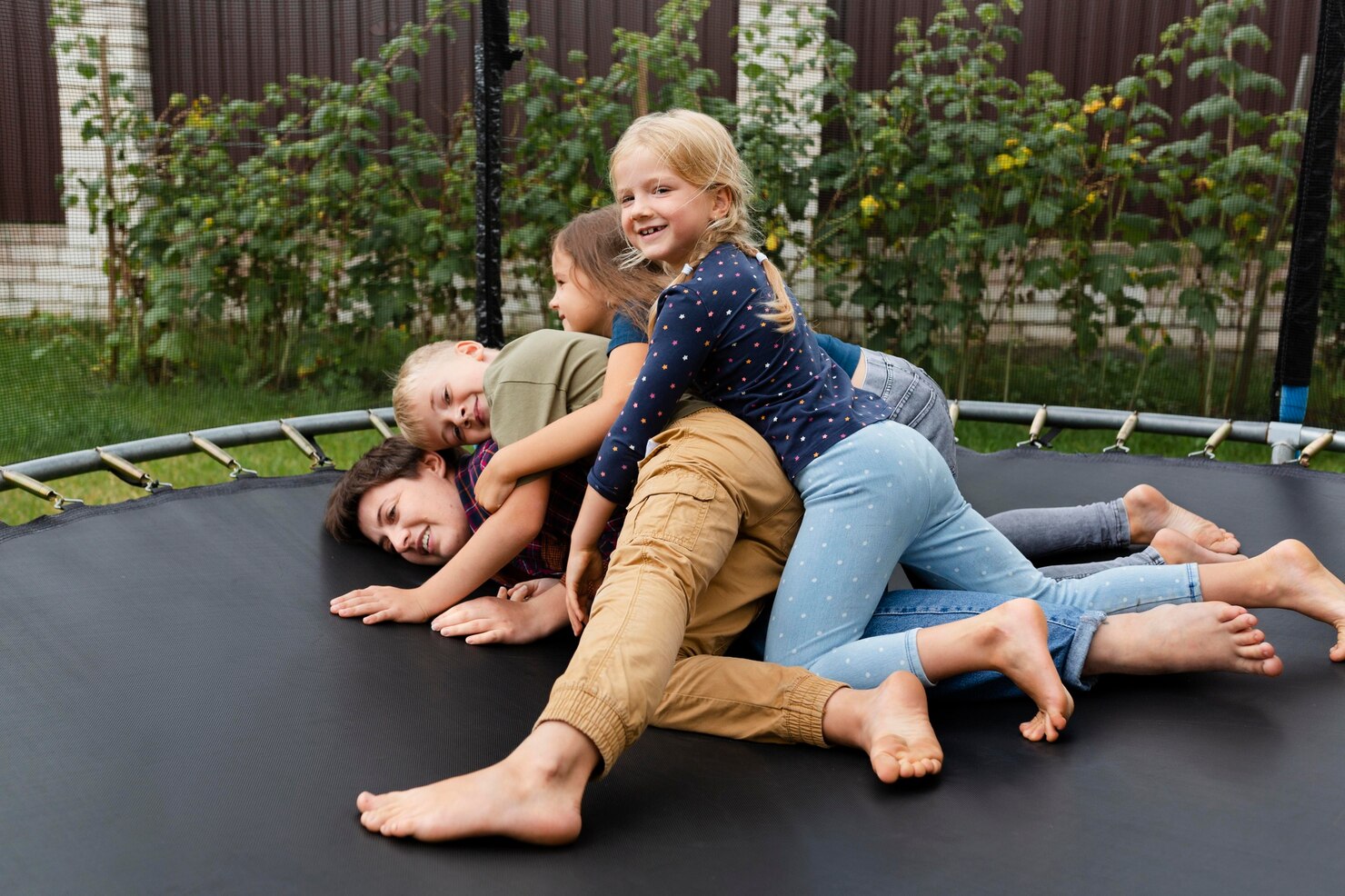 familie care se joacă în trambulină
