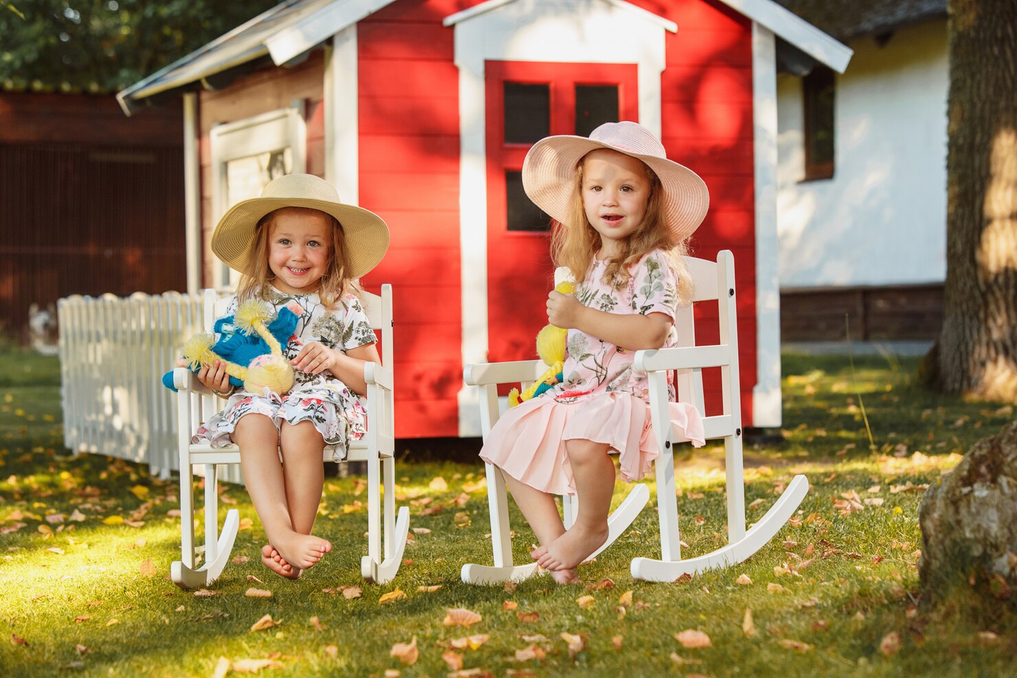 fetițe lângă o căsuță din lemn pentru copii