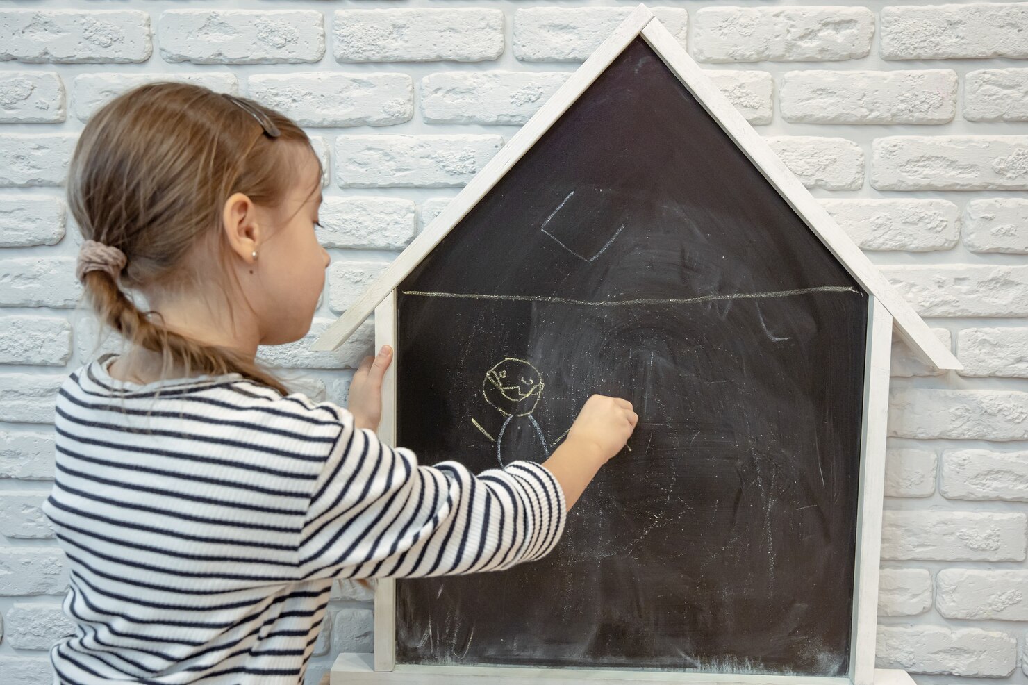 fetiță care scrie pe tablă
